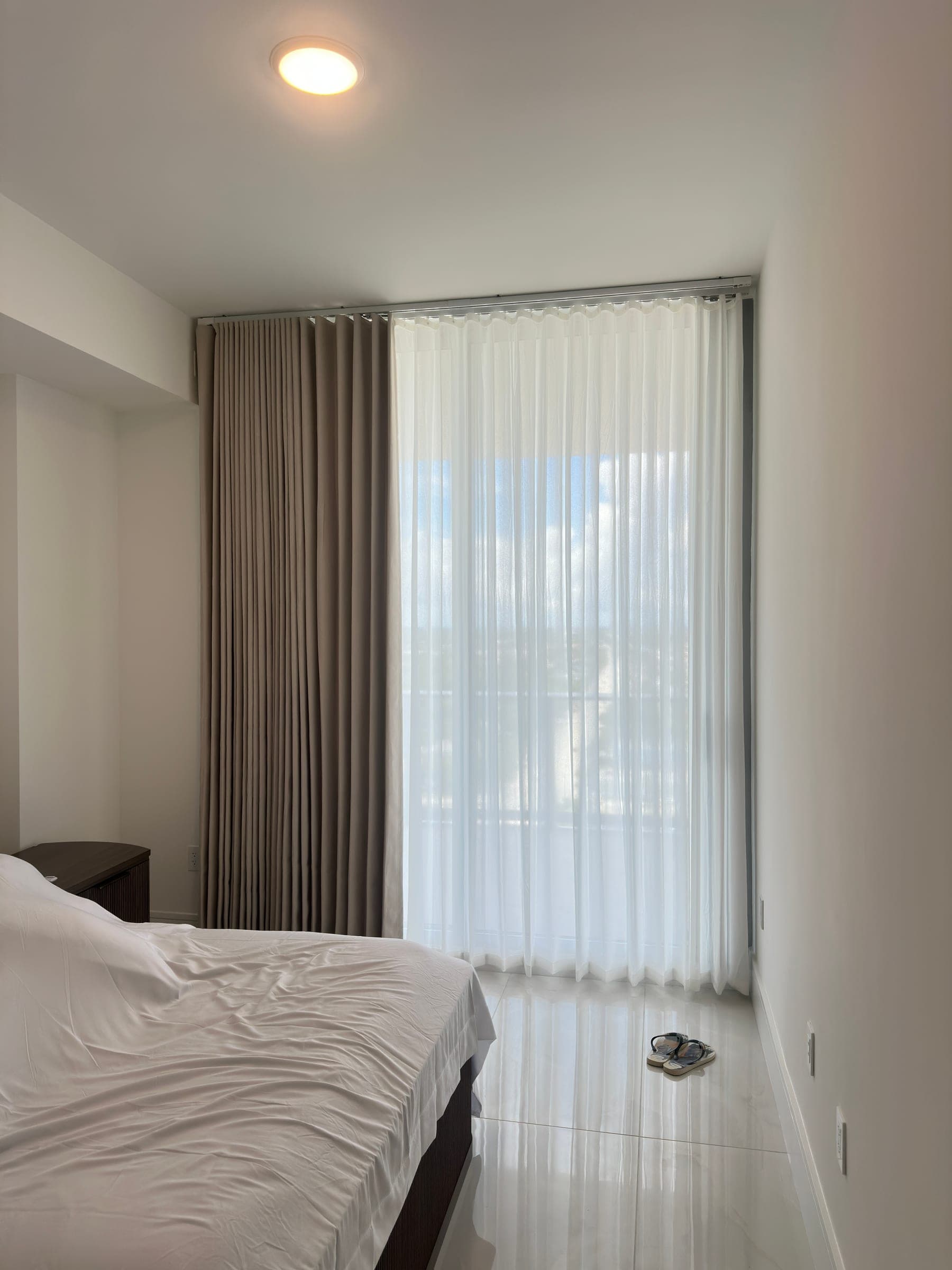 Layered bedroom drapery and sheer panels in a Miami high-rise
