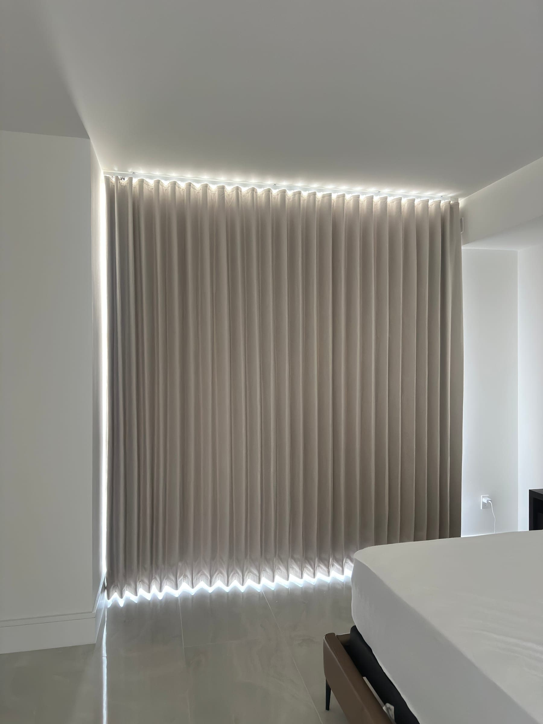 Closed bedroom drapery with ceiling track lighting in a Miami high-rise